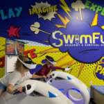 Mural depicting SwimFun logo and kids riding VR bikes